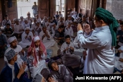 Pendiri sekolah Abu Kahfi (kanan) mengajar santri di pesantren anak tunarungu di Sleman. (Foto: AFP/Juni Kriswanto)