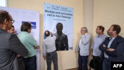 Journalists sign a banner calling to free WikiLeaks founder Julian Assange after a press conference at Geneva press club, in Geneva, June 22, 2022.