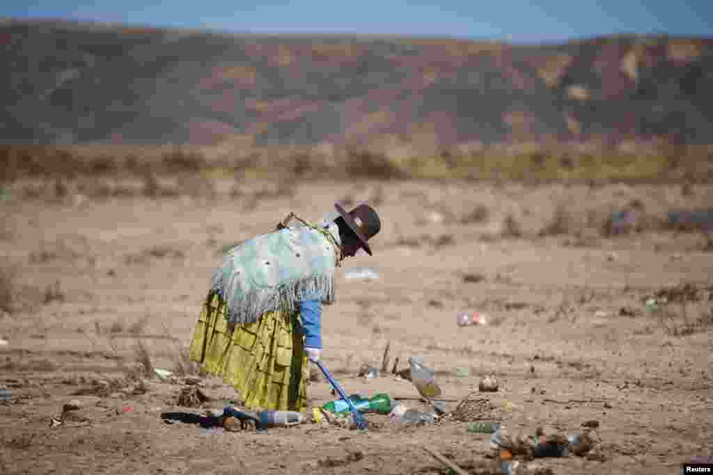 A volunteer cleans the banks of the Katari river which flows into Titicaca lake, near La Paz, Bolivia, June 19, 2022.