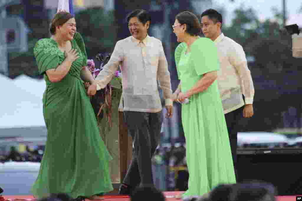 Vice President-elect Sara Duterte, left, the daughter of outgoing populist president of the Philippines, is greeted by incoming President Ferdinand &quot;Bongbong&quot; Marcos Jr. second from left, after oath-taking rites in her hometown in Davao city, southern Philippines.