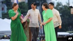 Wakil Presiden terpilih Filipina Sara Duterte, kiri, putri mantan presiden Filipina yang populis, disambut oleh Presiden Filipina Ferdinand "Bongbong" Marcos Jr. kedua dari kiri, setelah upacara pengambilan sumpah di Davao, selatan Filipina pada Minggu 19 Juni 2022. (Foto: AP)