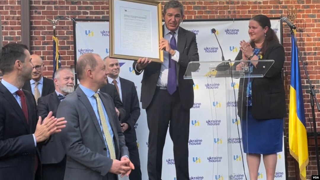 The European Union’s ambassador to the United States Stavros Lambrinidis presented Oksana Markarova, Ukraine’s ambassador to the U.S., a copy of the European Council’s agreement to accept Ukraine as a candidate for member state with all EU ambassadors in the U.S.’s signatures on it at an event on June 28, 2022 held at the Ukraine House in Washington marking Ukrainian Constitution Day. (Natalie Liu/VOA)