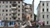 Ukrainski spasilac ispred zgrade delimično uništene u ruskom raketnom udaru u Harkovu, 11. jula 2022.