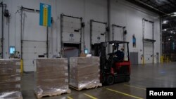 A Pfizer employee moves the boxes containing Paxlovid, COVID-19 treatment pills, with a forklift at a distribution facility in Memphis, Tennessee.