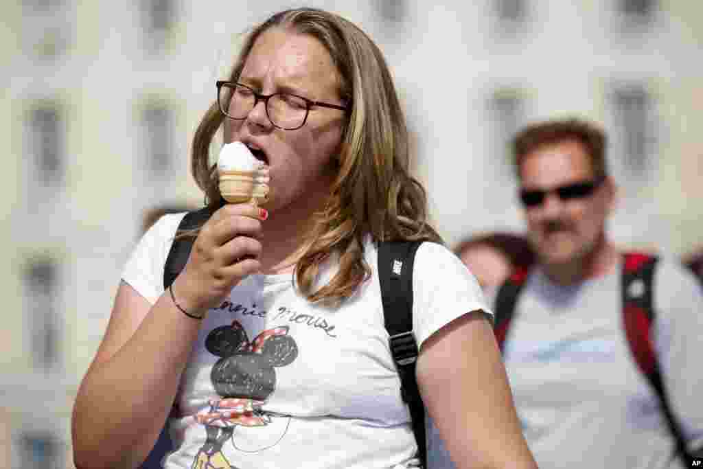 لندن میں گرمی سے بچنے کے لیے خاتون آئس کریم کھا کر لطف اندوز ہو رہی ہیں۔&nbsp;