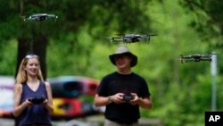 Quincey Johnson, left, and Martin Lively, fly their drones during a training session, Tuesday, June 7, 2022, in Poolesville, Md. (AP Photo/Julio Cortez)