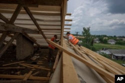 Civilians rebuild their homes after being destroyed by Russian strikes, Yahidne village, Ukraine, Wednesday, June 29, 2022. (AP Photo/Nariman El-Mofty)