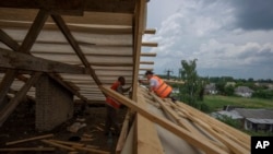 Civilians rebuild their homes after being destroyed by Russian strikes, Yahidne village, Ukraine, Wednesday, June 29, 2022. (AP Photo/Nariman El-Mofty)