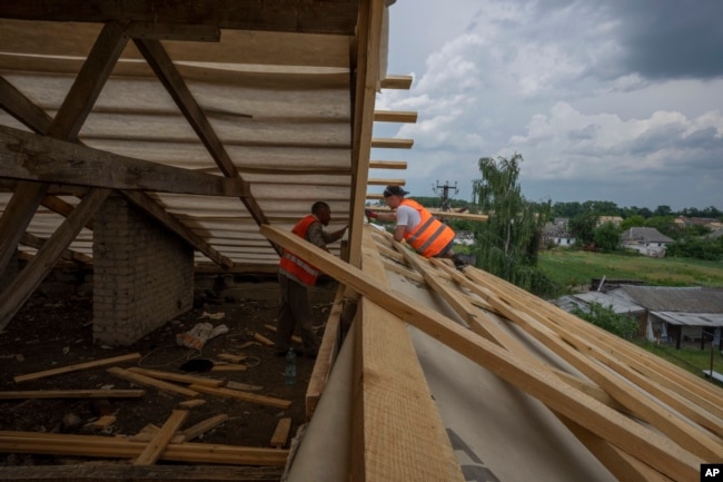 Civilians rebuild their homes after being destroyed by Russian strikes, Yahidne village, Ukraine, Wednesday, June 29, 2022. (AP Photo/Nariman El-Mofty)