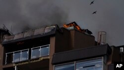 Birds fly over a residential building following explosions in Kyiv, Ukraine, June 26, 2022. 