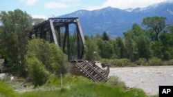 Jembatan rel kereta yang melintasi sungai Yellowstone rusak akibat banjir yang melanda kawasan Taman Nasional Yellowstone. Foto diambil di Livingston, Montana, pada 15 Juni 2022. (Foto: AP/Rick Bowmer)