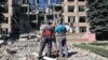 Radnici ispred razorene zgrade u Harkovu (Foto: SERGEY BOBOK / AFP)