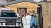 Members of the South African Police Service (SAPS) and forensic pathology service inspect the scene of a mass shooting in Soweto, South Africa, July 10, 2022. 