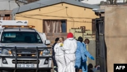 Members of the South African Police Service (SAPS) and forensic pathology service inspect the scene of a mass shooting in Soweto, South Africa, on July 10, 2022. - Fourteen people were killed during a shootout in a bar in Soweto police said on July 10, 20