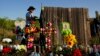 Roberto Marquez of Dallas secures a cross to a makeshift memorial at the site where officials found dozens of people dead in an abandoned semitrailer containing suspected migrants, June 29, 2022, in San Antonio.