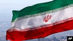 Bendera nasional Iran dengan lambang Republik Islam Iran (foto: dok). 