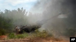 Ukrainian soldiers fire at Russian positions from a U.S.-supplied M777 howitzer in Ukraine's eastern Donetsk region, June 18, 2022. 