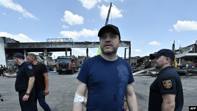 Ukraine's Minister of Internal Affairs Denys Monastyrsky, center, visits the site of the destroyed Amstor mall in Kremenchuk, on June 28, 2022, one day after it was hit by a Russian missile strike.