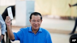 Cambodian Prime Minister Hun Sen, of the Cambodian People's Party (CPP), holds his ballot before dropping it into a ballot box at a polling station in Takhmua in Kandal province, southeast of Phnom Penh, Cambodia, June 5, 2022. 