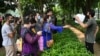 FILE - Afghan people gather outside the embassy of the United States of America in New Delhi on Aug. 19, 2021, to submit documents to apply for a visa. The cost of applying for a visa is prohibitive for many Afghan students wanting to study in the U.S.