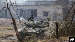 Umusirikare wa Ukraine uhagaze iruhande rw'imbunda nini
