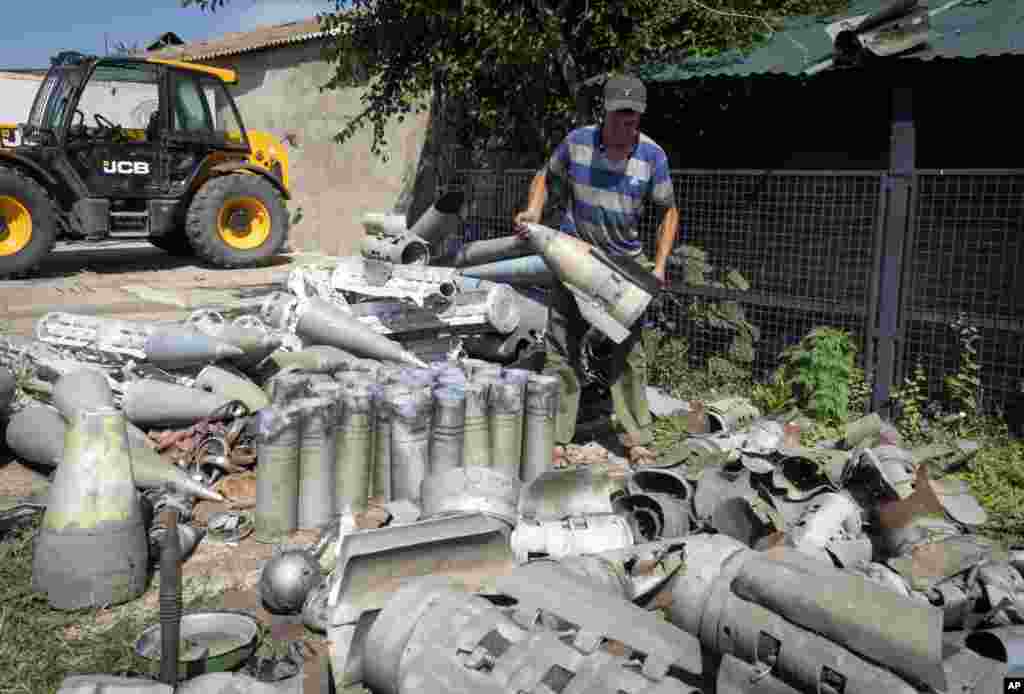 A farmer collects fragments of Russian rockets that he found on his field ten kilometers from the front line in the Dnipropetrovsk region, Ukraine.