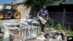 Un agricultor recoge fragmentos de cohetes rusos que encontró en su propiedad, a diez kilómetros de la línea del frente en la región de Dnipropetrovsk, Ucrania, el 4 de julio de 2022.