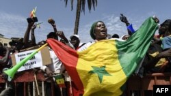 Une manifestante tient le drapeau du Sénégal lors d'un rassemblement de l'opposition sénégalaise sur la place de l'Obélisque à Dakar, le 8 juin 202.