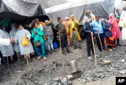 Umat Hindu terlihat terdampar setelah hujan deras di dekat base camp kuil gua suci Amarnath di selatan Kashmir Himalaya, di India, 8 Juli 2022. (Foto: via AP)