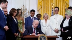 President Joe Biden signs an executive order at an event to celebrate Pride Month in the East Room of the White House, Wednesday, June 15, 2022, in Washington.