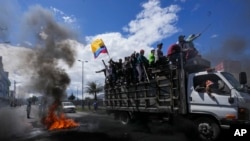 Manifestantes antigubernamentales pasan frente a una barricada en llamas durante protestas contra el gobierno del presidente Guillermo Lasso convocadas principalmente por organizaciones indígenas, el jueves 16 de junio de 2022, en Quito, Ecuador. 