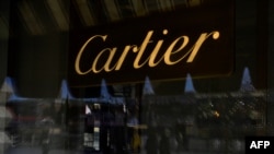 FILE - Passersby are seen reflected in the Cartier boutique window in Moscow, March 9, 2022.