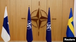 FILE - The flags of Finland, NATO and Sweden are seen during a ceremony to mark Sweden's and Finland's application for membership in Brussels, Belgium, May 18, 2022. 