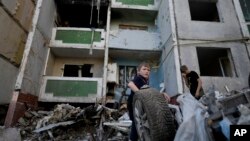 Deca stoje ispred stambene zgreade uništene tokom bombardovanja Černigiva, Ukraina, 19. juna 2022.