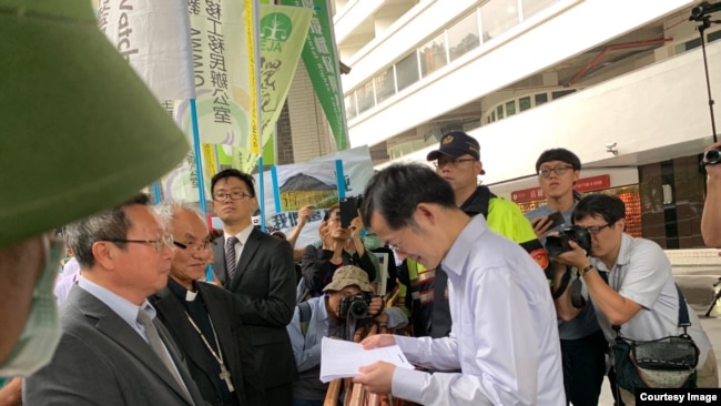 Đại diện Formosa nhận thông cáo báo chí của các luật sư và các tổ chức tranh đấu cho môi trường và nhân quyền Đài Loan (Ảnh do JFFV cung cấp)