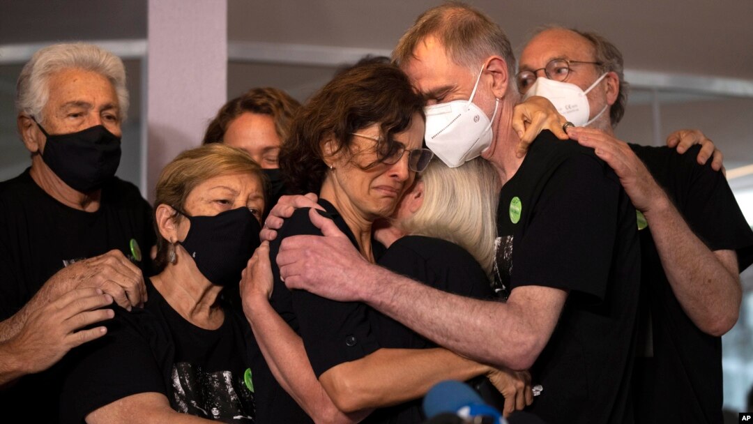 Para kerabat dari jurnalis Dom Phillips memeluk Alessandra Sampaio (tengah), istri dari Phillips, dalam konferensi pers pada acara pemakaman Phillips di Niteroi, Brazil, pada 26 Juni 2022. (Foto: AP/Silvia Izquierdo)