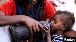 FILE - A severely malnourished child drinks from a bottle at a camp for internally displaced people in Afdera town, Afar region, Ethiopia, Feb. 23, 2022. 