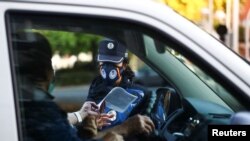 ARCHIVO - Un agente de la Policía Local revisa la documentación de un conductor durante un control rutinario, en Madrid, en septiembre de 2021.