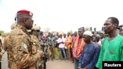 Burkina Faso President Lt. Colonel Paul-Henri Damiba talks to local people in Seytenga, Burkina Faso, June 15, 2022, three days after armed men killed at least 79 people. 