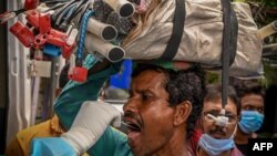 Health workers collect swab samples from commuters for COVID-19 coronavirus screening after a surge in number infections in Kolkata on July 4, 2022.