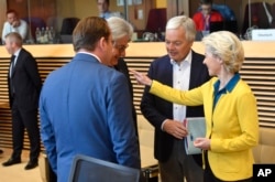 European Commission President Ursula von der Leyen, right, speaks with colleagues during a meeting of the College of Commissioners at EU headquarters in Brussels, June 17, 2022.