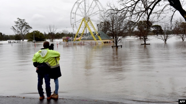 People look at a flooded park due to torrential rain in the Camden suburb of Sydney, Australia, July 3, 2022.