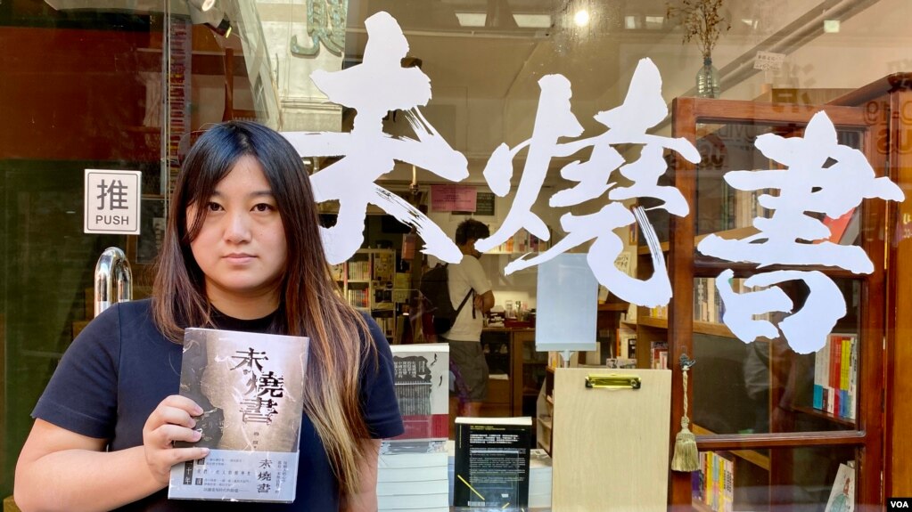 香港猎人书店店长 黄文萱 手持6月主题书《未烧书》。 (美国之音/汤惠芸(photo:VOA)