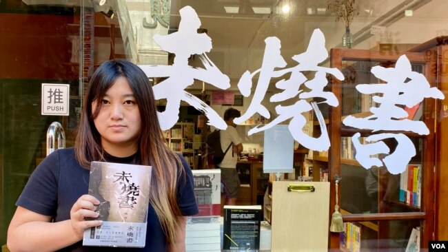 香港猎人书店店长 黄文萱 手持6月主题书《未烧书》。 (美国之音/汤惠芸