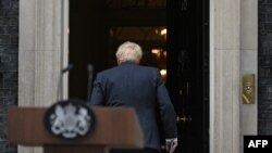 Britain's Prime Minister Boris Johnson walks back into 10 Downing Street in central London after making a statement. Johnson quit as Conservative party leader after three tumultuous years in charge.