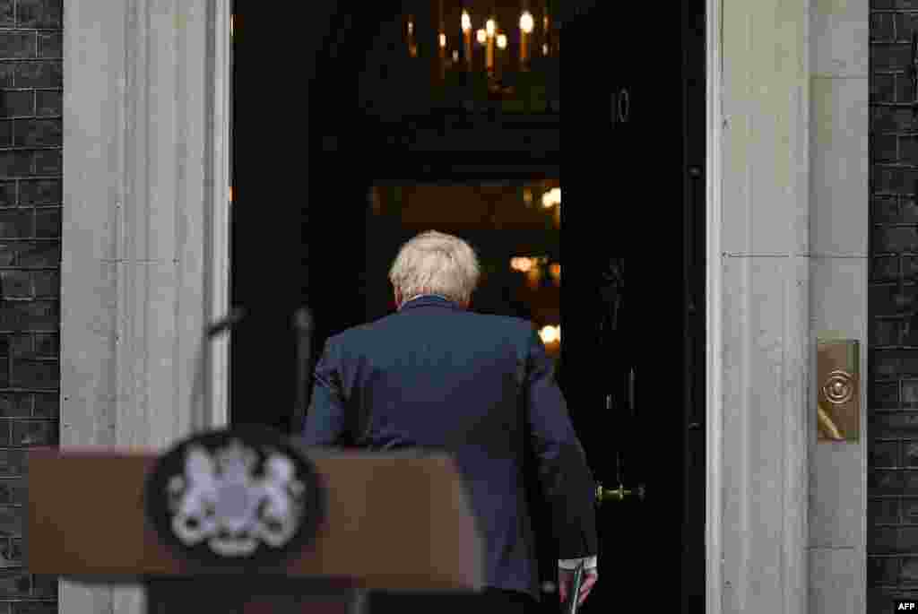 Britain's Prime Minister Boris Johnson walks back into 10 Downing Street in central London after making a statement. Johnson quit as Conservative party leader after three tumultuous years in charge.