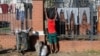 A refugee man hangs his clothes on the fence of the United Nations High Commissioner for Refugees office premises in Pretoria, South Africa, on June 1, 2022. 