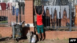 A refugee man hangs his clothes on the fence of the United Nations High Commissioner for Refugees office premises in Pretoria, South Africa, on June 1, 2022. 