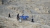 FILE - Volunteers carry aid being received from the International Organization for Migration (IOM) for recent earthquake affected people in the Afghan-Dubai village of Spera district in Khost province, June 26, 2022. 