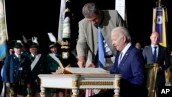 Presiden AS Joe Biden menandatangani buku tamu setibanya di Munich, Jerman didampingi oleh Perdana Menteri Bavaria Markus Soeder di Bandara Internasional Munich, Sabtu, 25 Januari 2022. ( Foto: AP Photo/Susan Walsh)